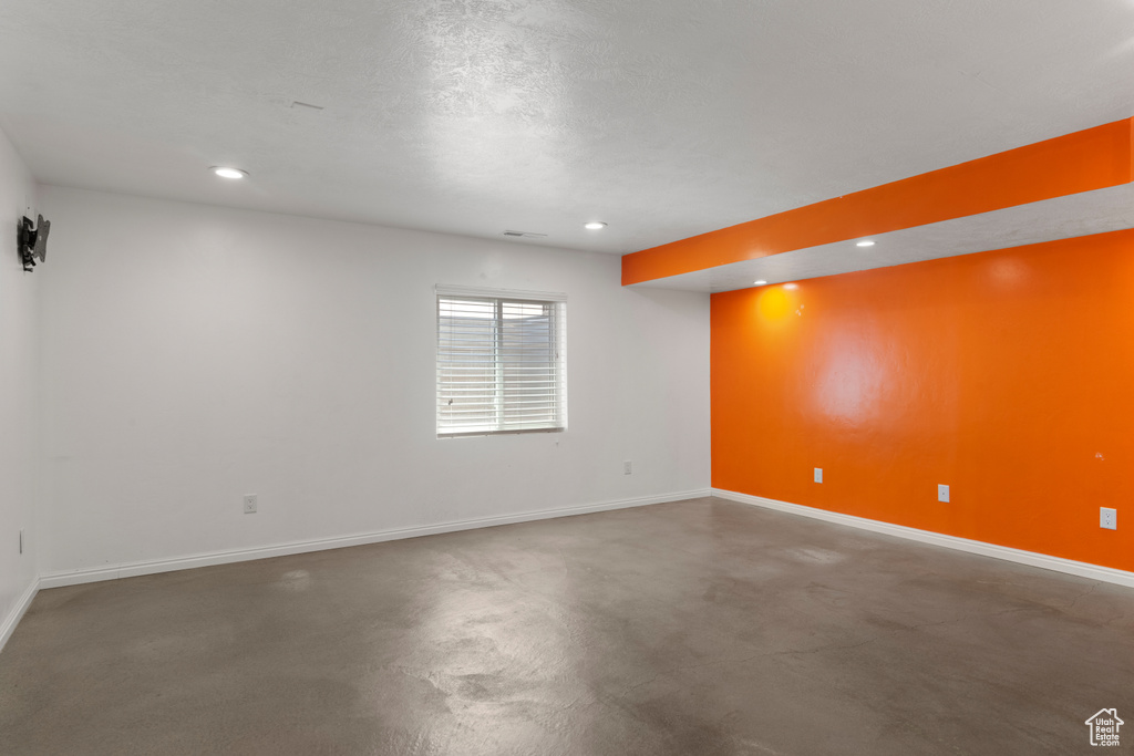 Unfurnished room featuring baseboards, recessed lighting, and finished concrete flooring