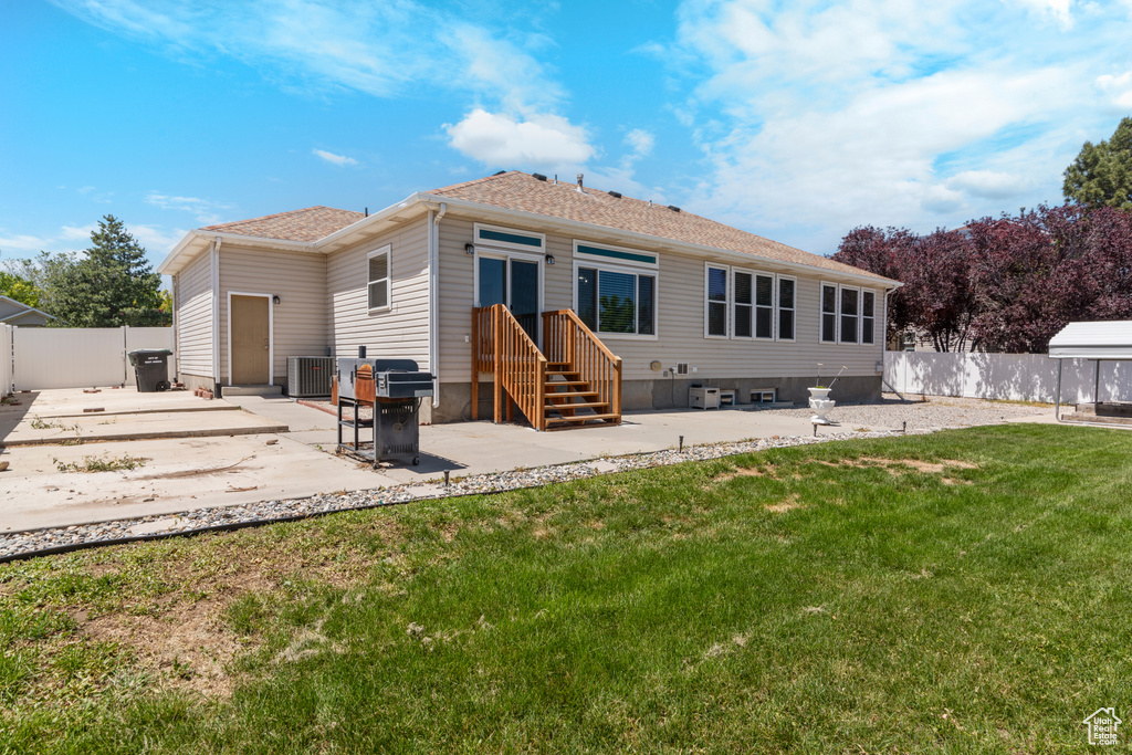 Rear view of property featuring cooling unit, a patio, and a shingled roof