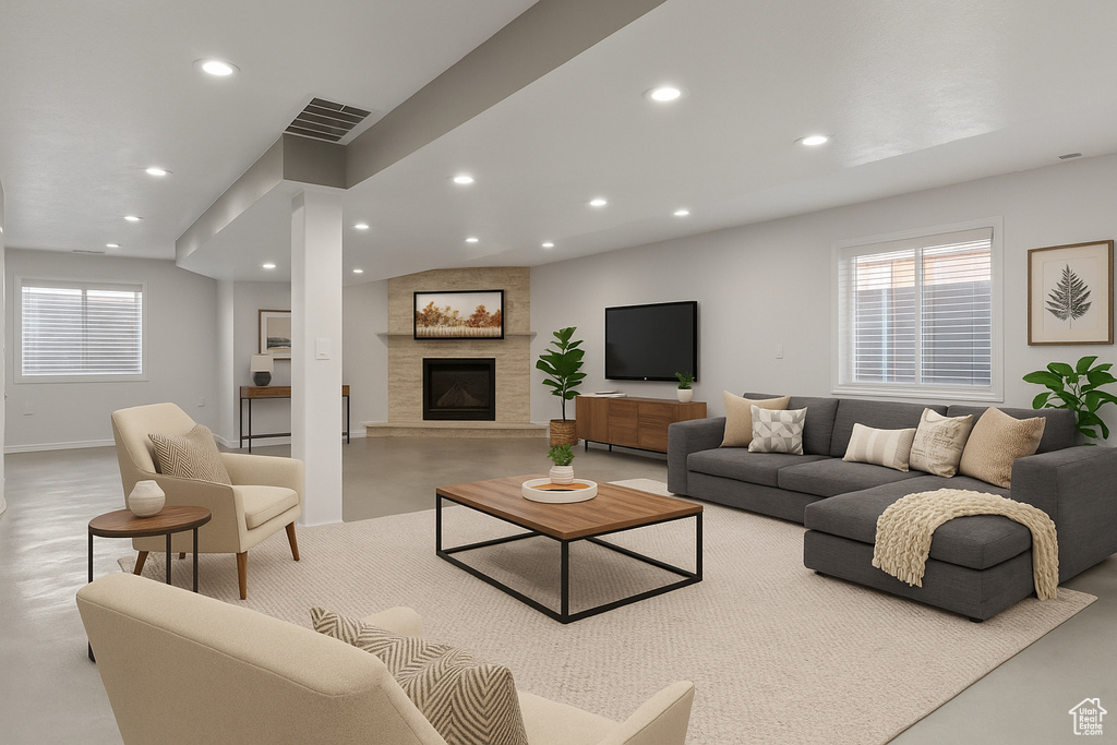 Living area with concrete floors, recessed lighting, plenty of natural light, a fireplace, and baseboards