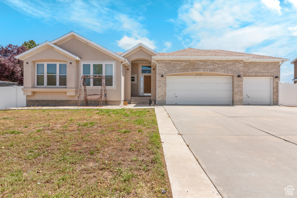 Ranch-style house with an attached garage, driveway, and brick siding