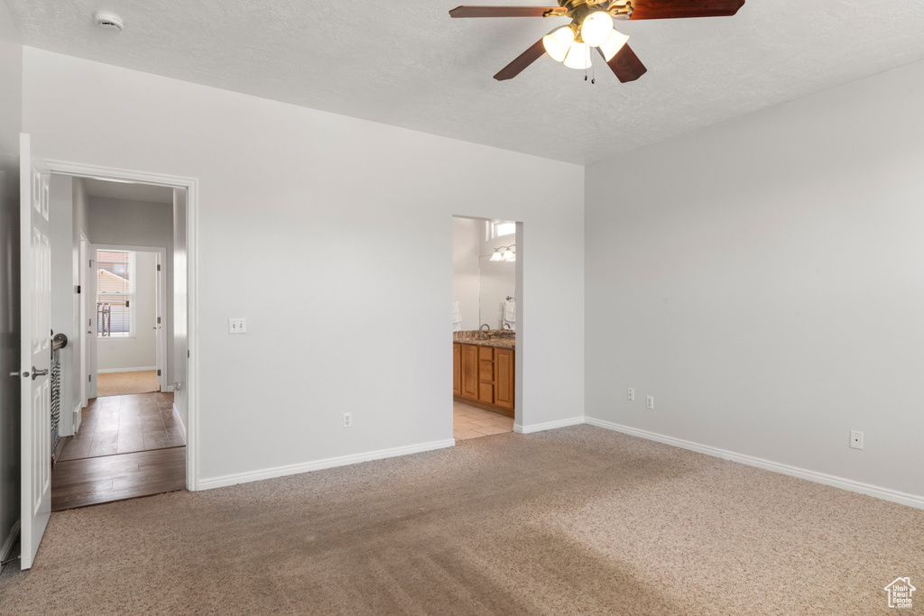Unfurnished room featuring ceiling fan, light carpet, a smoke detector, and baseboards