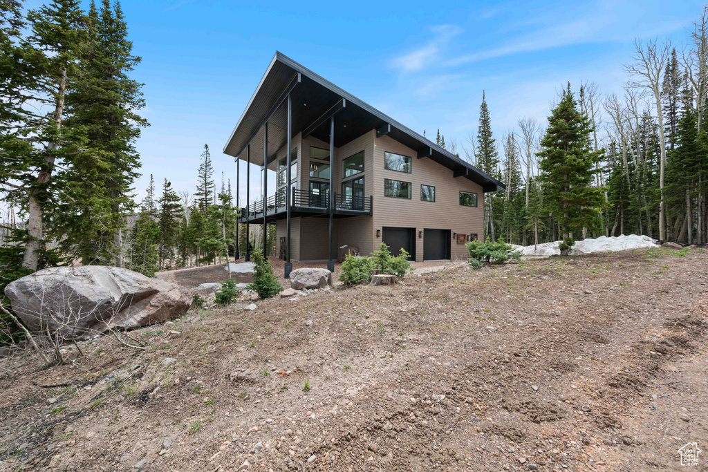 View of property exterior featuring a garage and dirt driveway