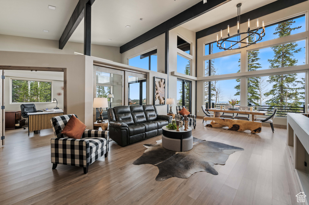 Living area with wood finished floors, an office area, and a chandelier