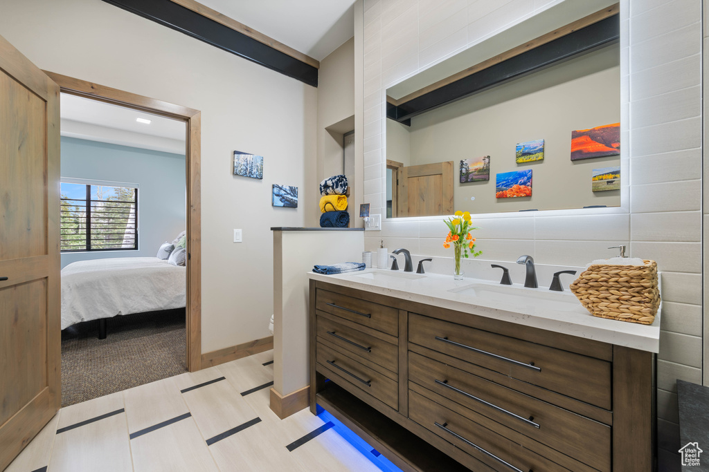 Full bath with double vanity, toilet, and ensuite bath