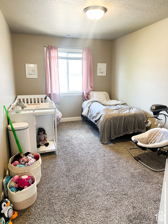 Carpeted bedroom with a textured ceiling