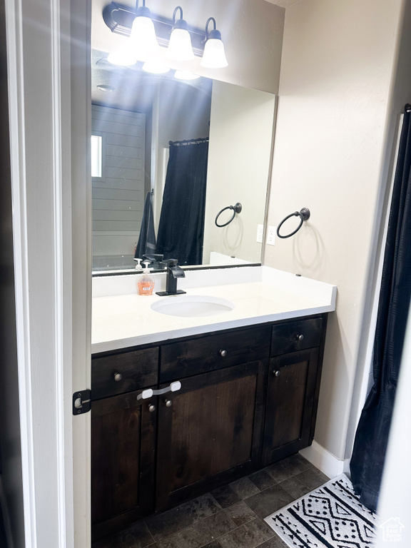 Full bath with vanity and stone finish floors