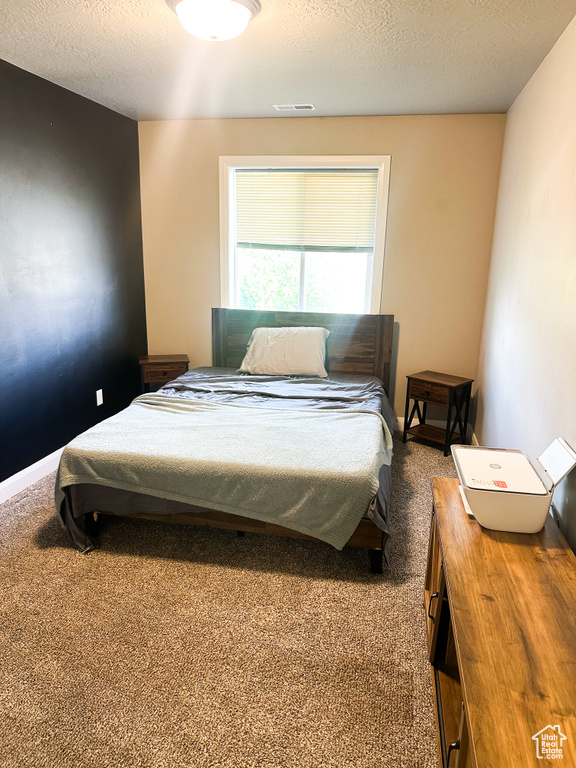 Bedroom featuring carpet and a textured ceiling