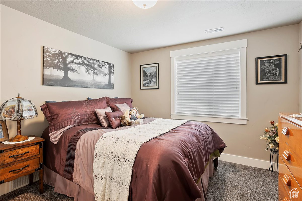 Bedroom featuring carpet and baseboards