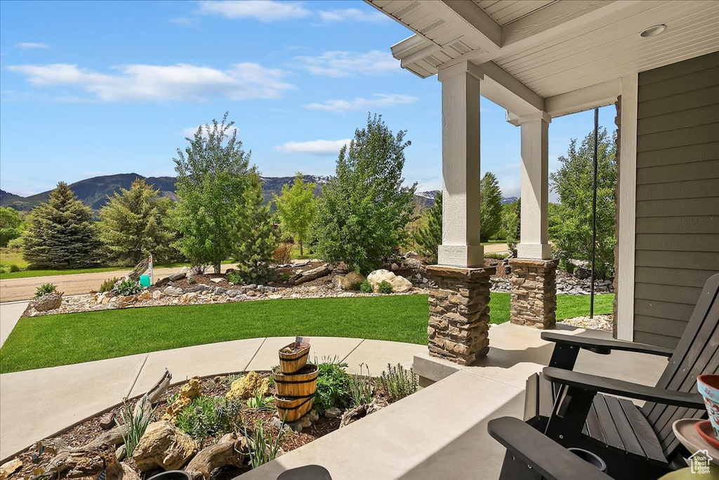 Porch featuring a mountain view and a yard