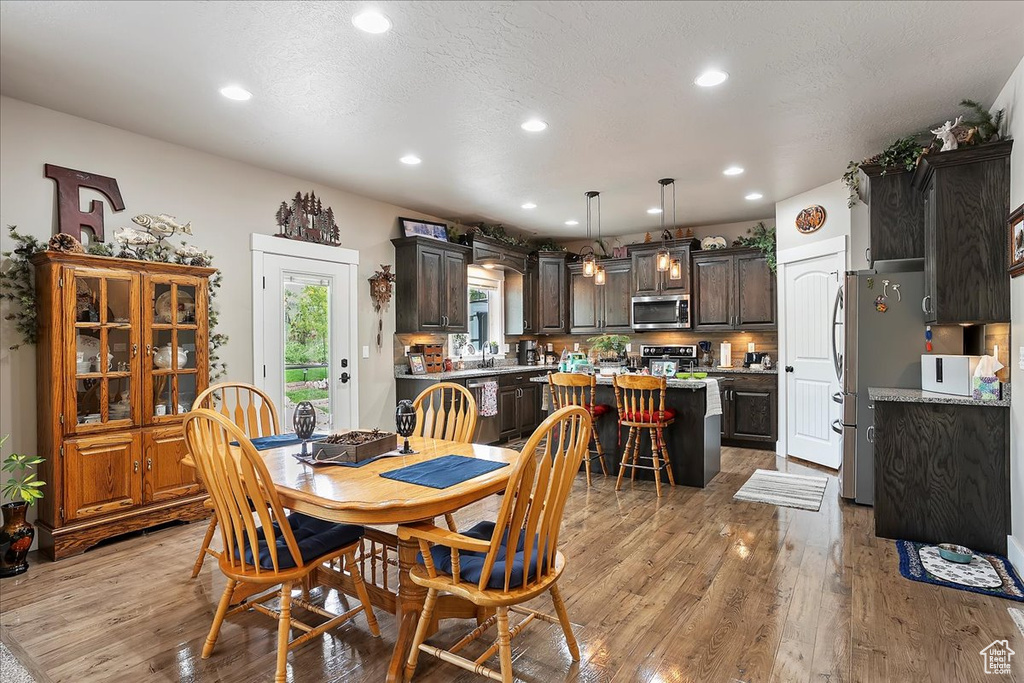 Dining room with light wood-type flooring and recessed lighting