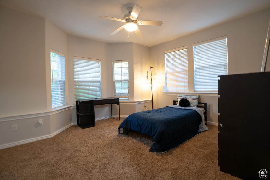 Carpeted bedroom with baseboards and ceiling fan