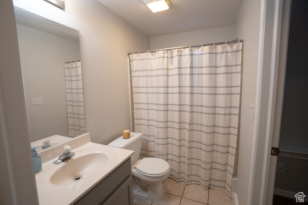 Full bath featuring toilet, vanity, tile patterned floors, and a shower with shower curtain