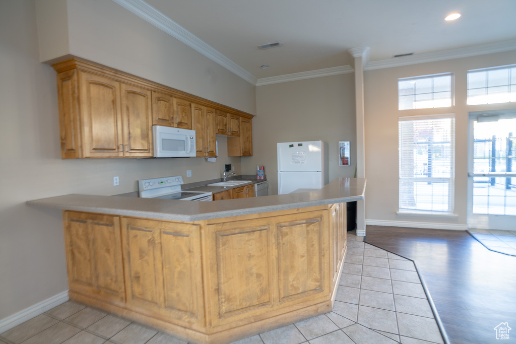 Kitchen featuring white appliances, ornamental molding, baseboards, light tile patterned floors, and a sink