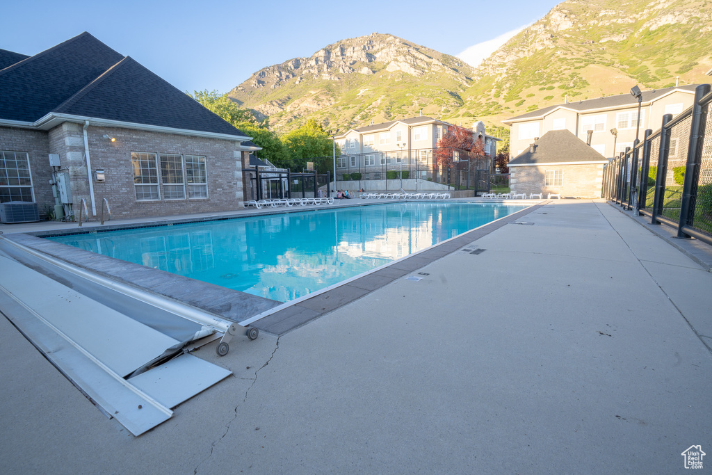 Community pool featuring a mountain view and central air condition unit
