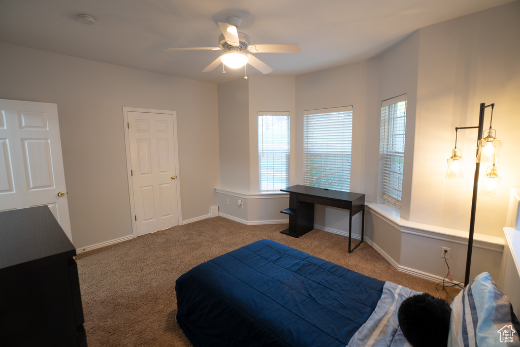 Carpeted bedroom featuring baseboards and ceiling fan