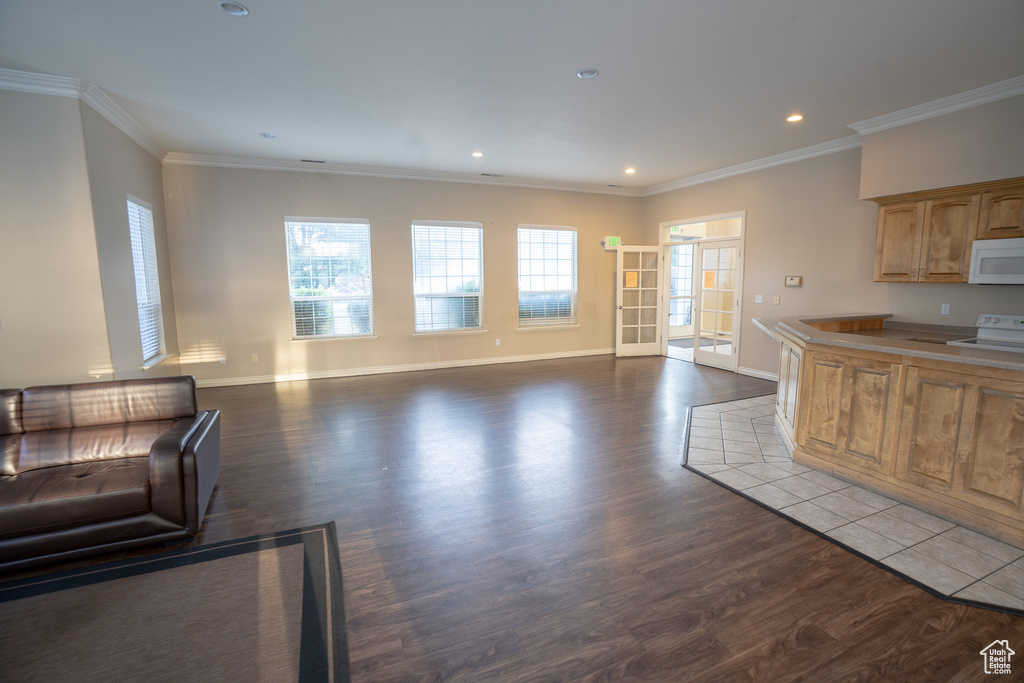 Kitchen featuring white appliances, dark wood finished floors, crown molding, baseboards, and recessed lighting