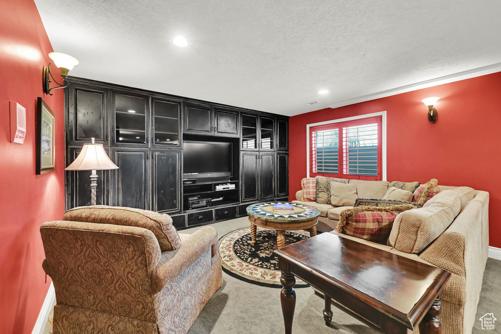 Living room featuring a textured ceiling, carpet floors, recessed lighting, and baseboards
