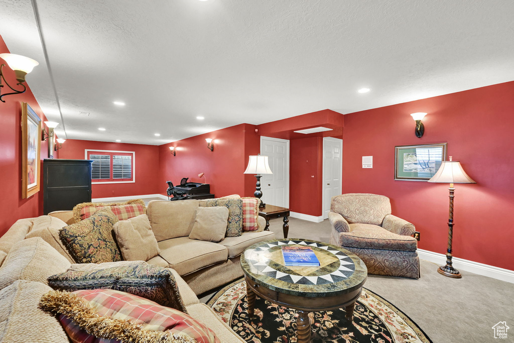 Carpeted living area featuring baseboards, recessed lighting, and a textured ceiling