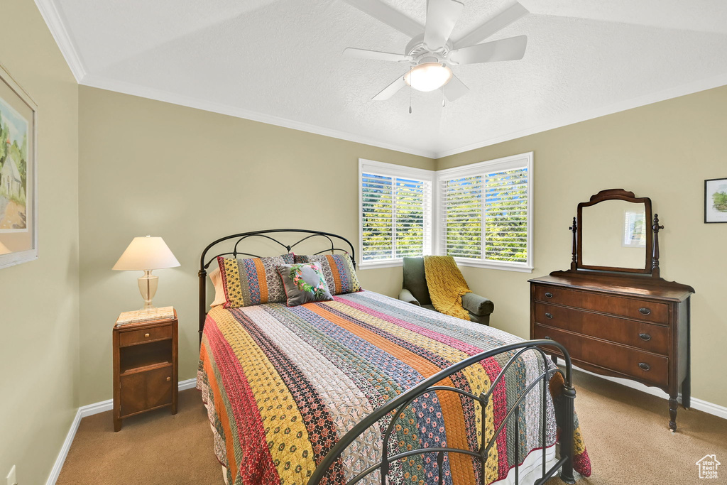 Bedroom featuring carpet, baseboards, ceiling fan, and ornamental molding