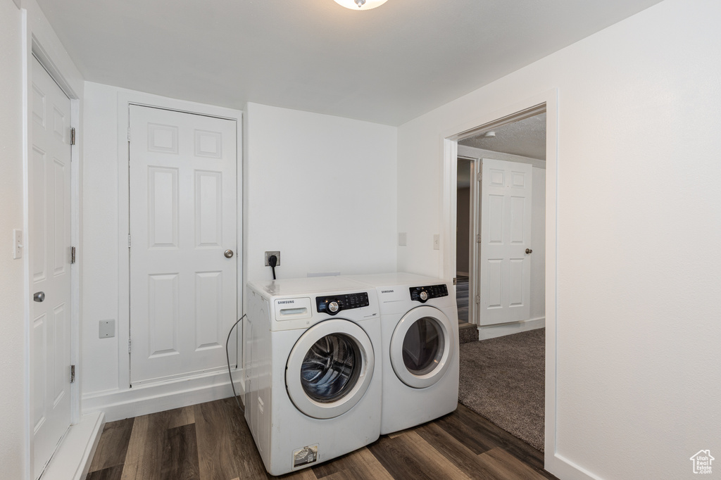 Washroom with washer and dryer and dark wood finished floors