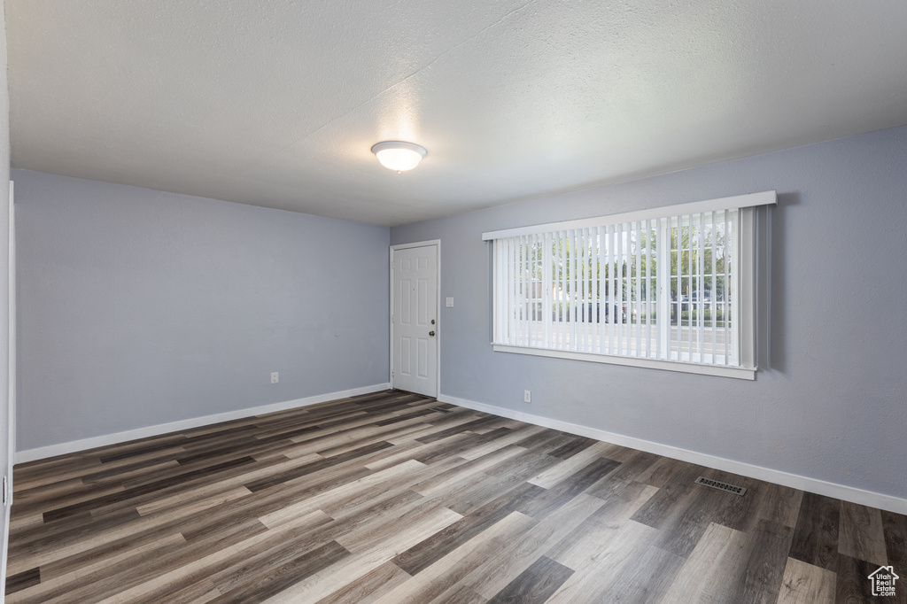 Unfurnished room featuring wood finished floors and baseboards