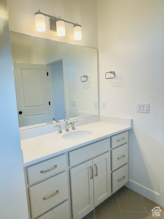 Bathroom with vanity, tile patterned floors, and baseboards