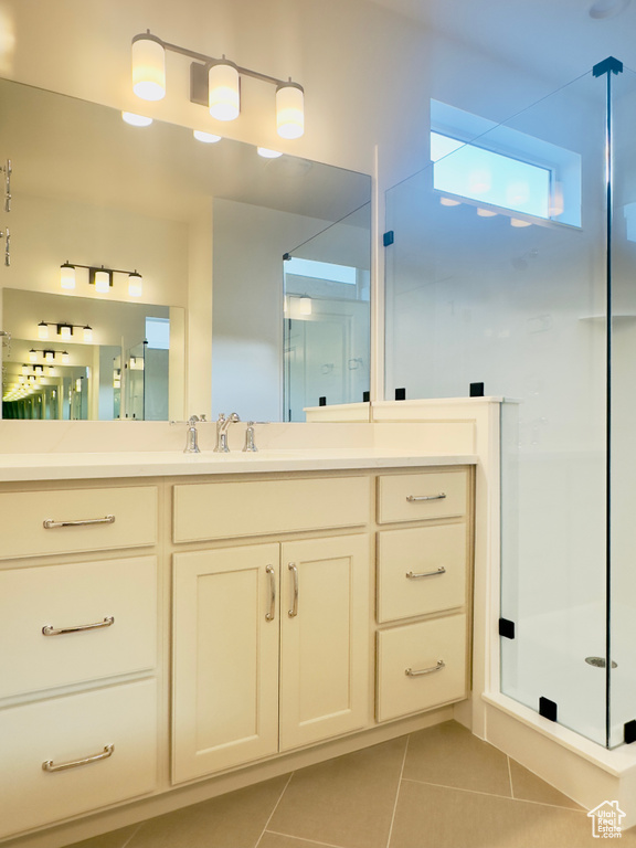 Bathroom featuring tile patterned floors, a shower stall, and vanity