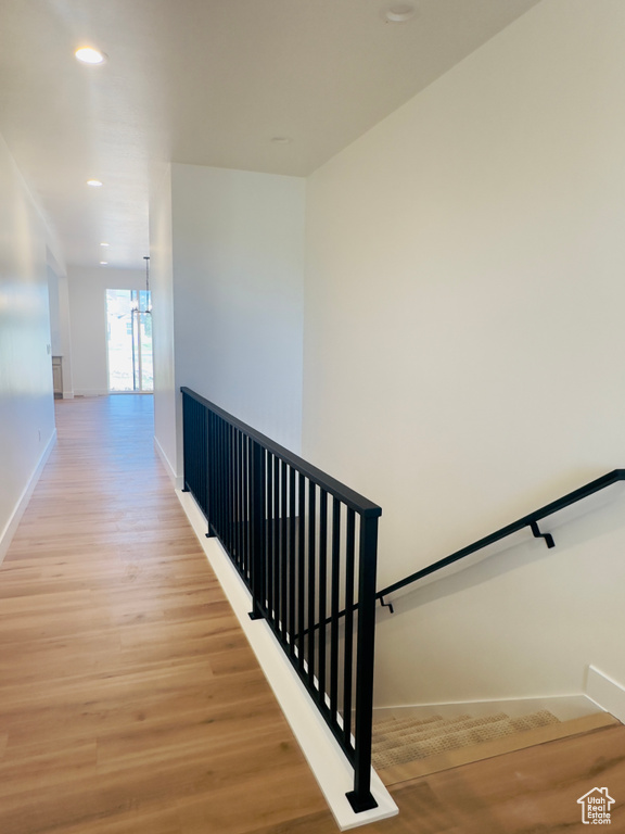Stairway with baseboards, wood finished floors, and recessed lighting
