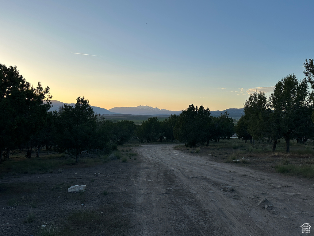 View of dirt / gravel road with a mountain view and a view of countryside