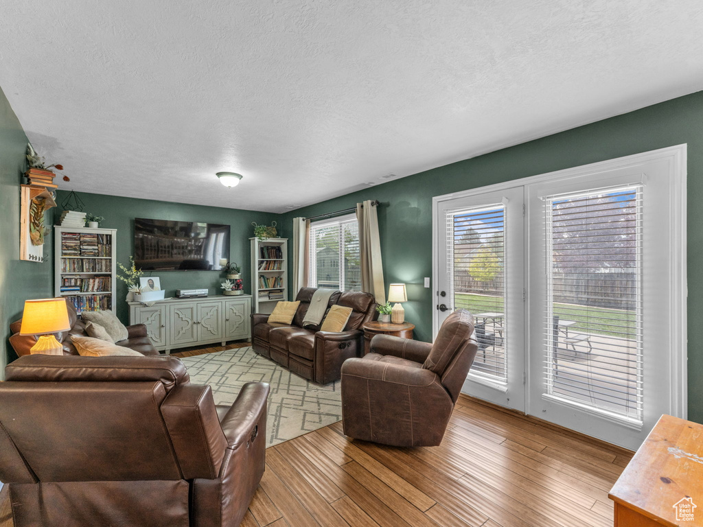Living room featuring light wood-style flooring and a textured ceiling