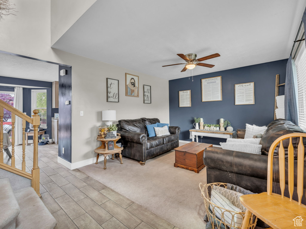 Living room featuring a ceiling fan, stairway, wood finish floors, and baseboards