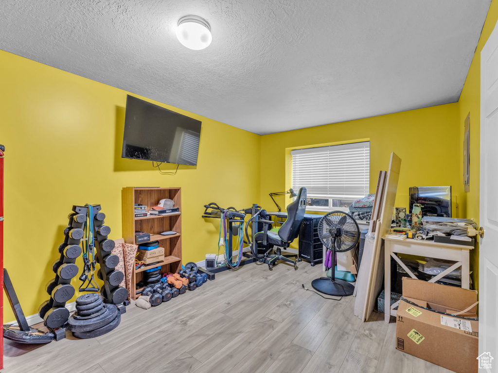 Workout area featuring wood finished floors and a textured ceiling
