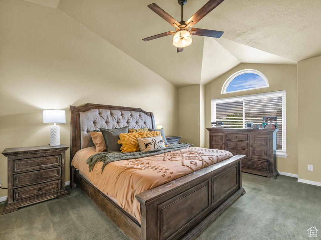 Carpeted bedroom featuring lofted ceiling, baseboards, and ceiling fan