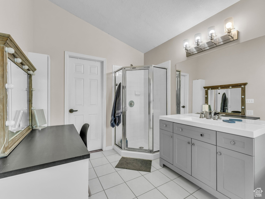 Full bath featuring a shower stall, vanity, lofted ceiling, and tile patterned floors