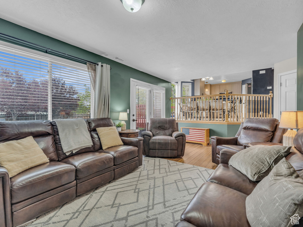 Living area with wood finished floors and a chandelier