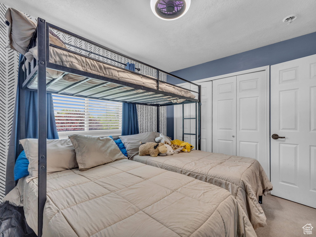 Carpeted bedroom with a closet