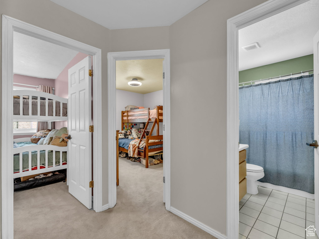 Hallway featuring light carpet and baseboards