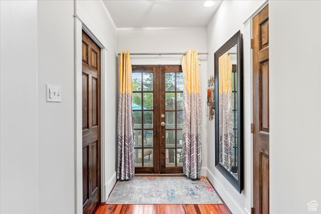 Entryway with french doors, wood finished floors, and baseboards