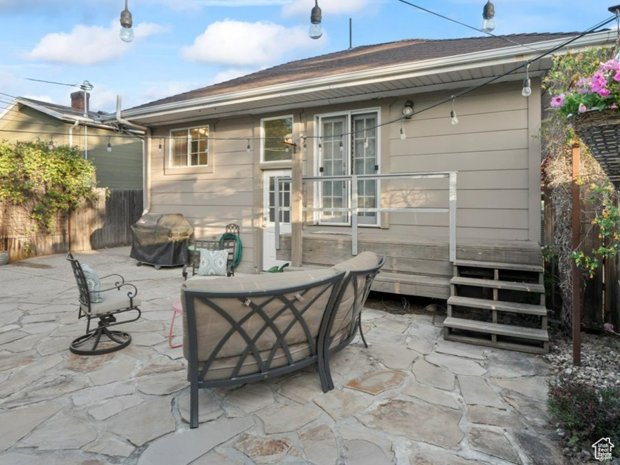 Rear view of house featuring a fenced backyard, an outdoor living space, and a patio area