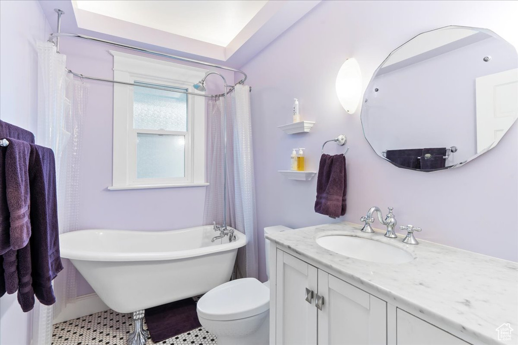 Bathroom with toilet, a freestanding tub, and vanity