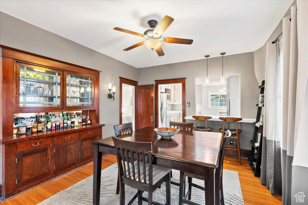 Dining room with a ceiling fan, light wood-type flooring, and plenty of natural light