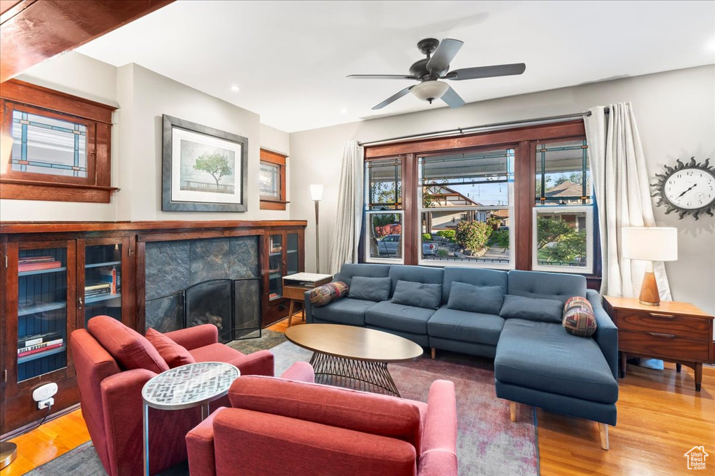 Living room featuring wood finished floors, recessed lighting, a fireplace, and ceiling fan