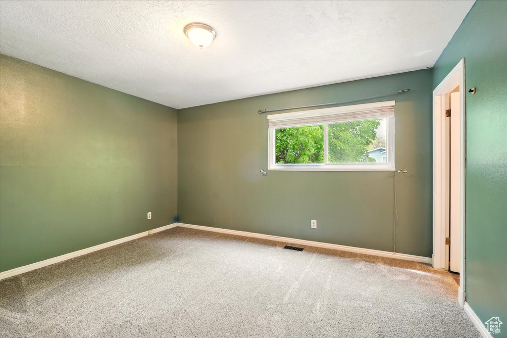 Spare room with carpet and baseboards
