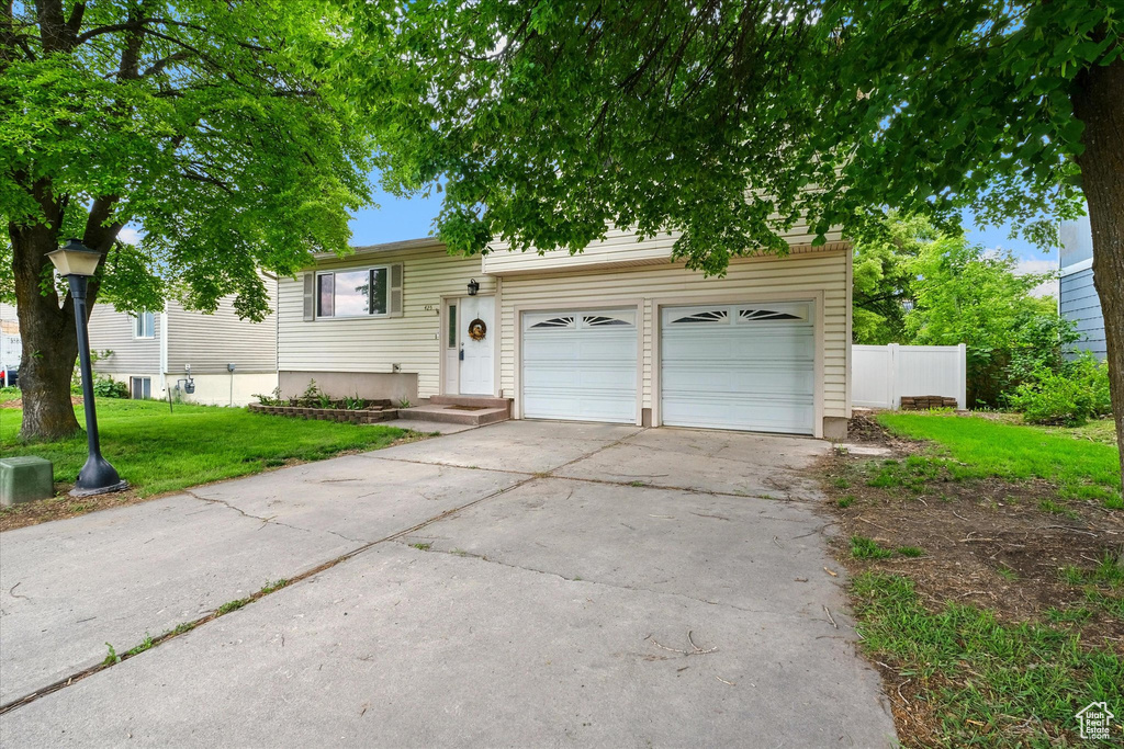 View of front facade with concrete driveway and a garage