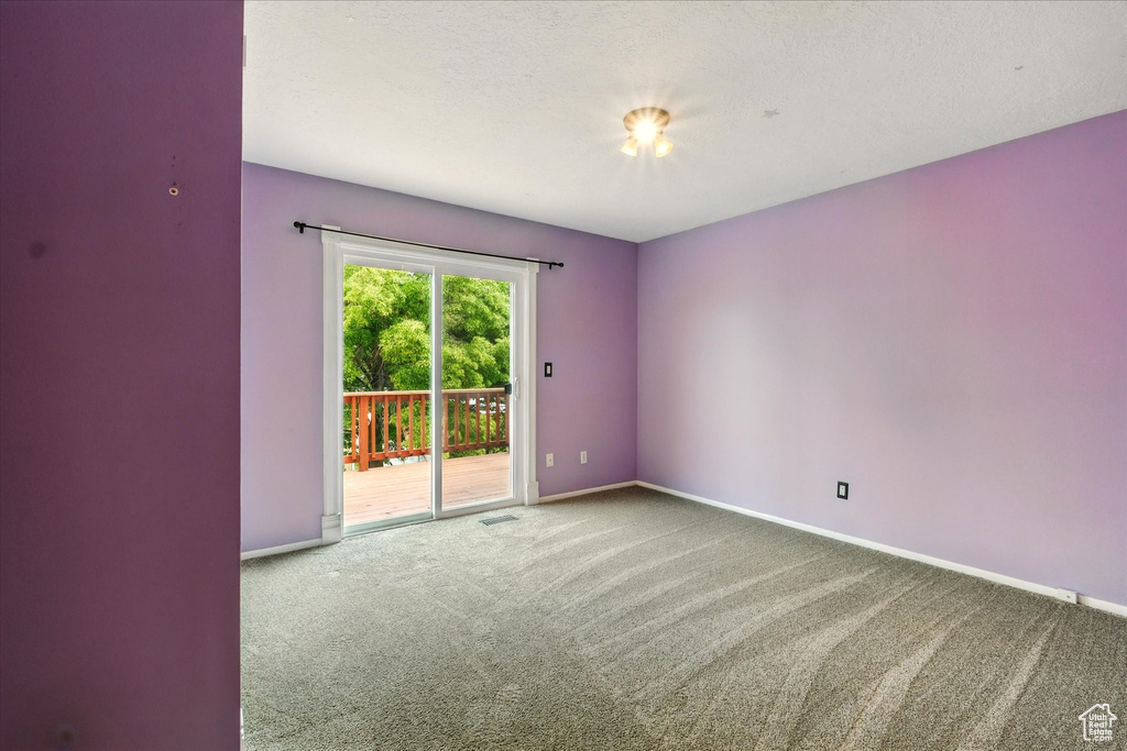 Carpeted empty room featuring baseboards