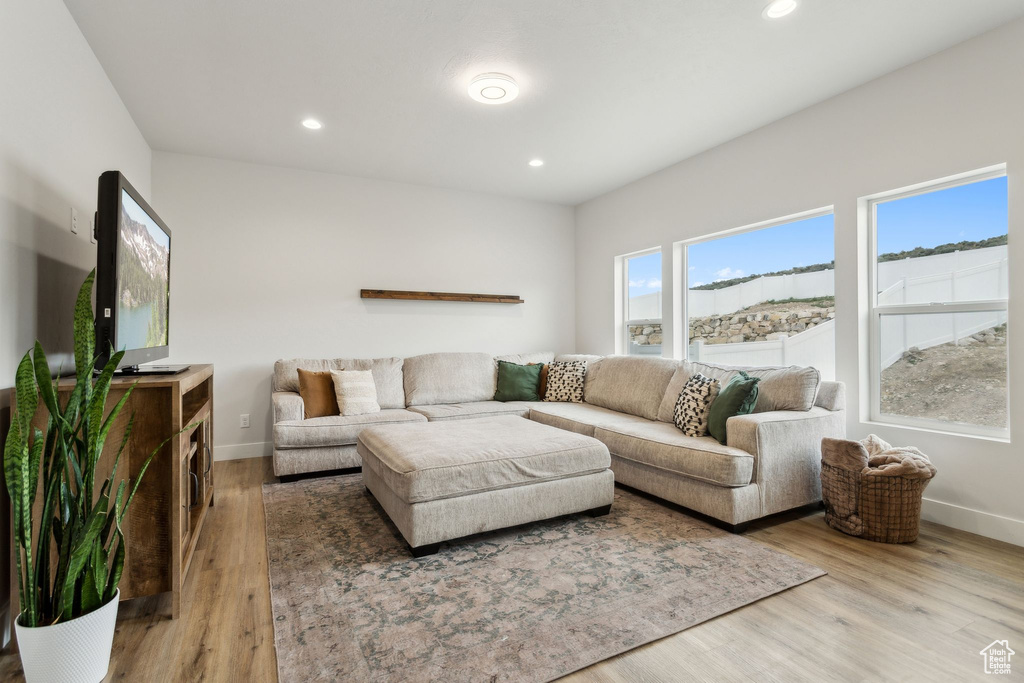 Living area with baseboards, wood finished floors, and recessed lighting