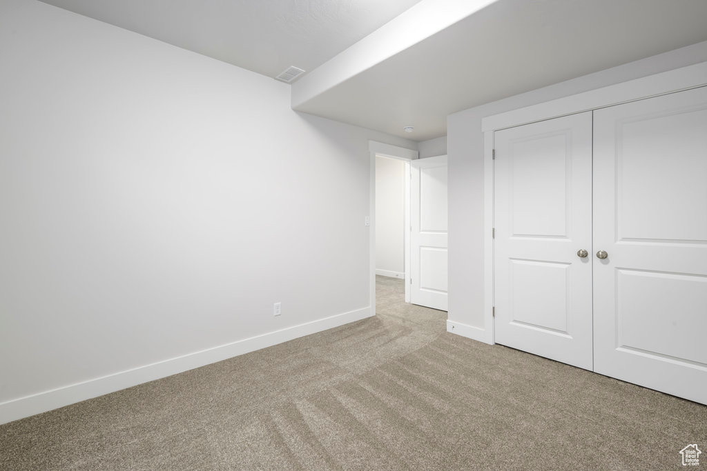 Unfurnished bedroom featuring carpet floors, baseboards, and a closet