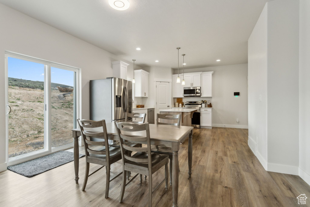 Dining area featuring wood finished floors, baseboards, and recessed lighting