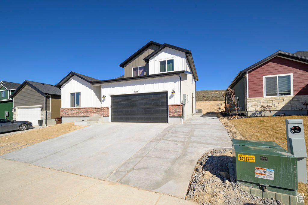 Modern farmhouse style home with board and batten siding, concrete driveway, and an attached garage