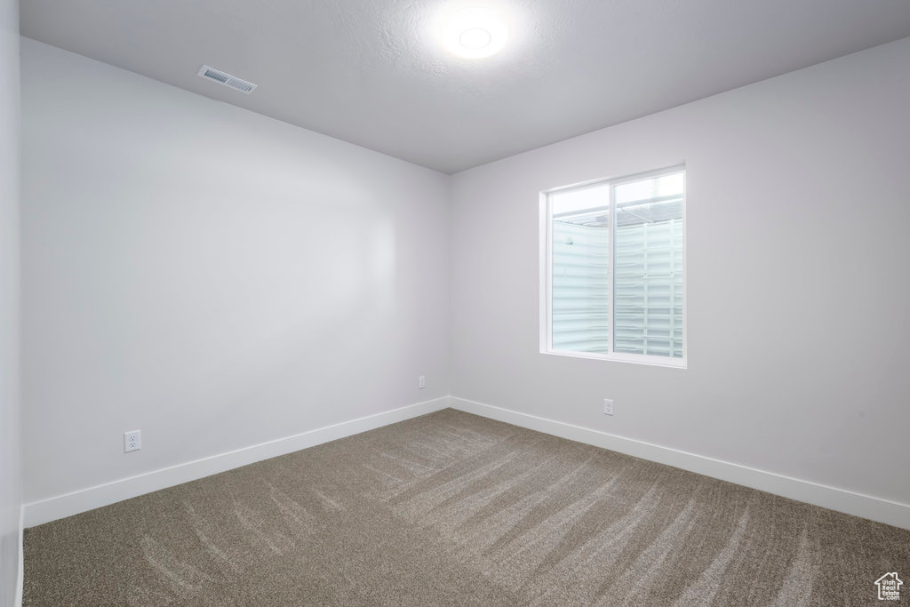 Carpeted empty room featuring baseboards